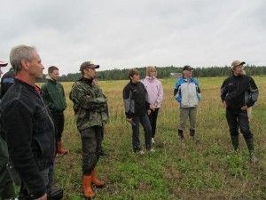 Foto 1: Fälträff vid Thomas Jakobsson (i mitten) med bra uppslutning. Regnet hängde i luften men vi klarade oss undan de värsta regnskurarna. På bilden står vi vid kanten av hans ekopotatisskifte och diskuterar hur hantera potatisbladmöglet i ekopotatisen. Thomas Snellmans franska gäst berättade att i Frankrike sprutas olika kopparlösningar för att skydda blasten. I Finland finns inga godkända kopparpreparat som kan användas för att bekämpa möglet.